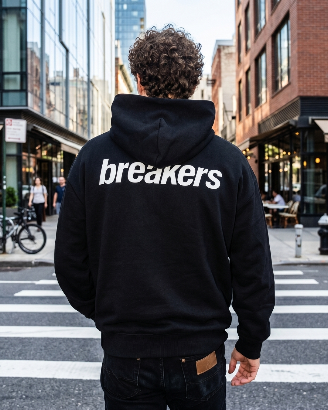 Person wearing a Lucy Breakers hoodie on a city street
